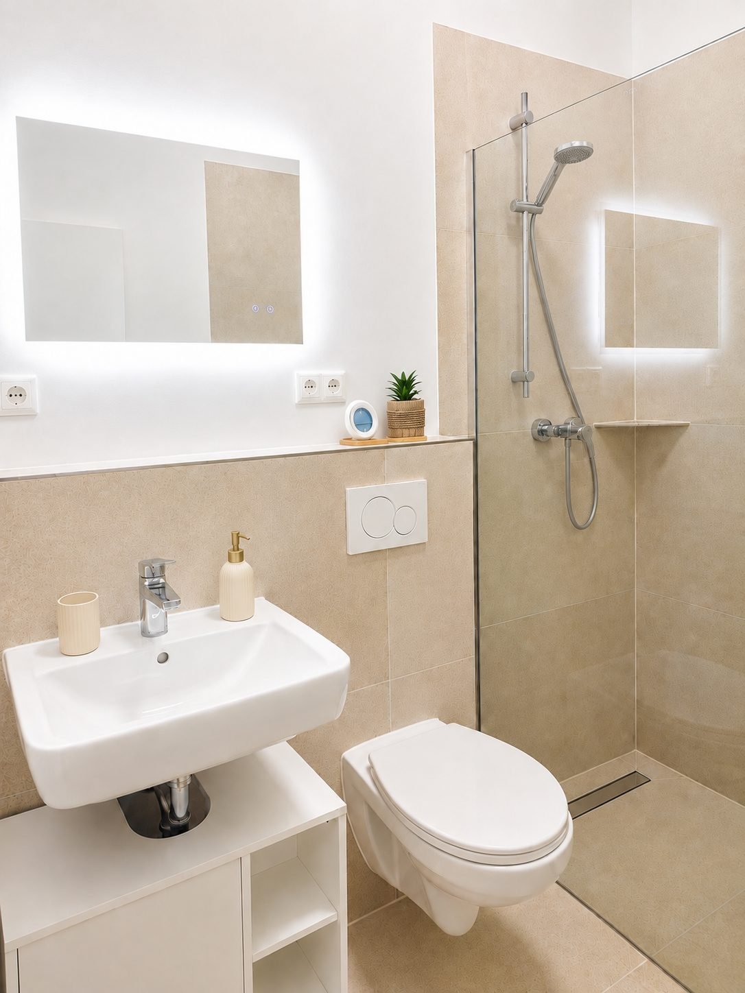 Badezimmer mit bodengleicher Dusche, Waschbecken und beleuchtetem Spiegel