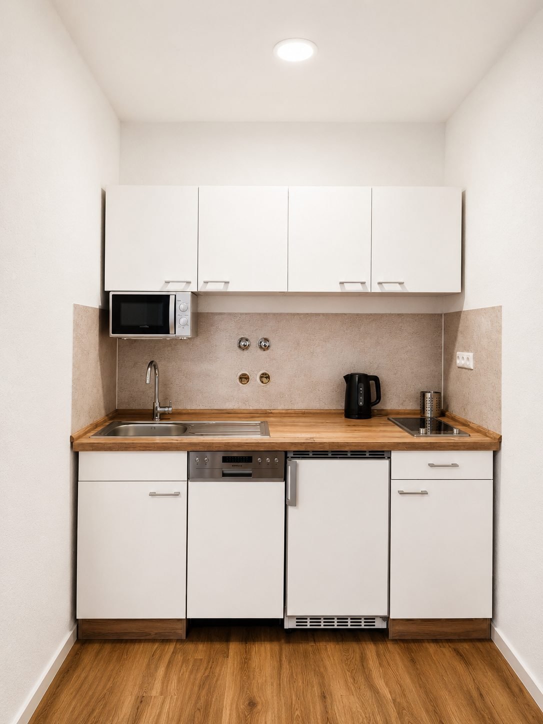 Küchenzeile mit Spüle, Kochfeld, Kühlschrank, Spülmaschine und Mikrowelle