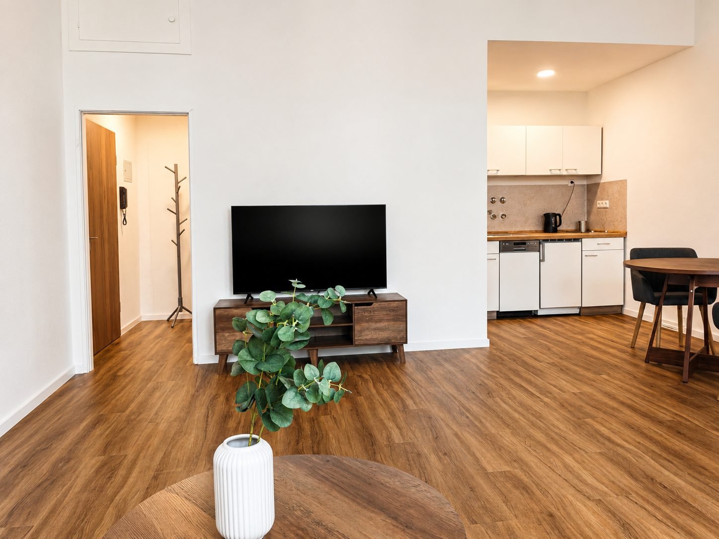 Wohnbereich mit Fernseher und Blick in die Küche